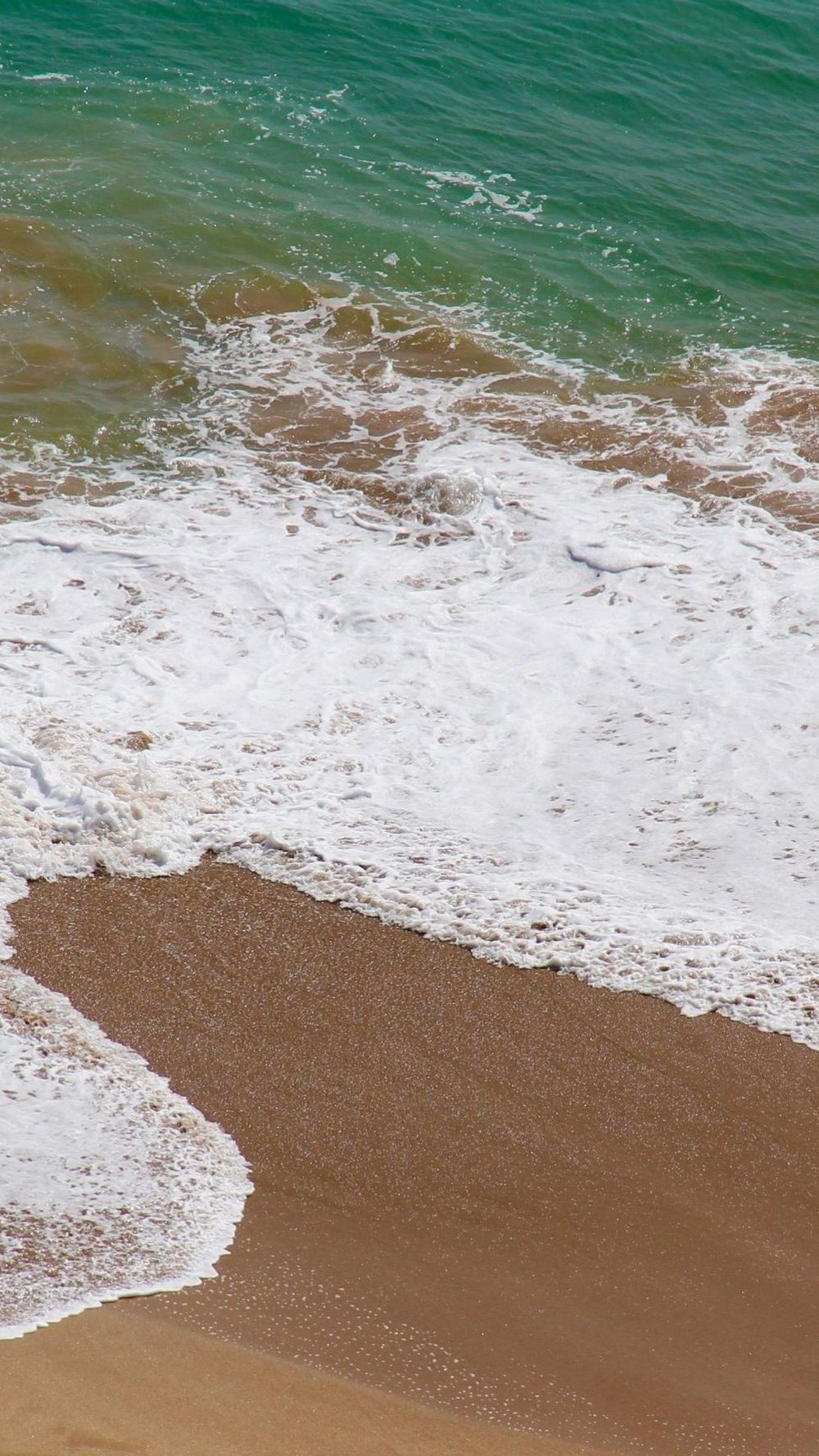 海湾中拍打白色沙滩的浪花