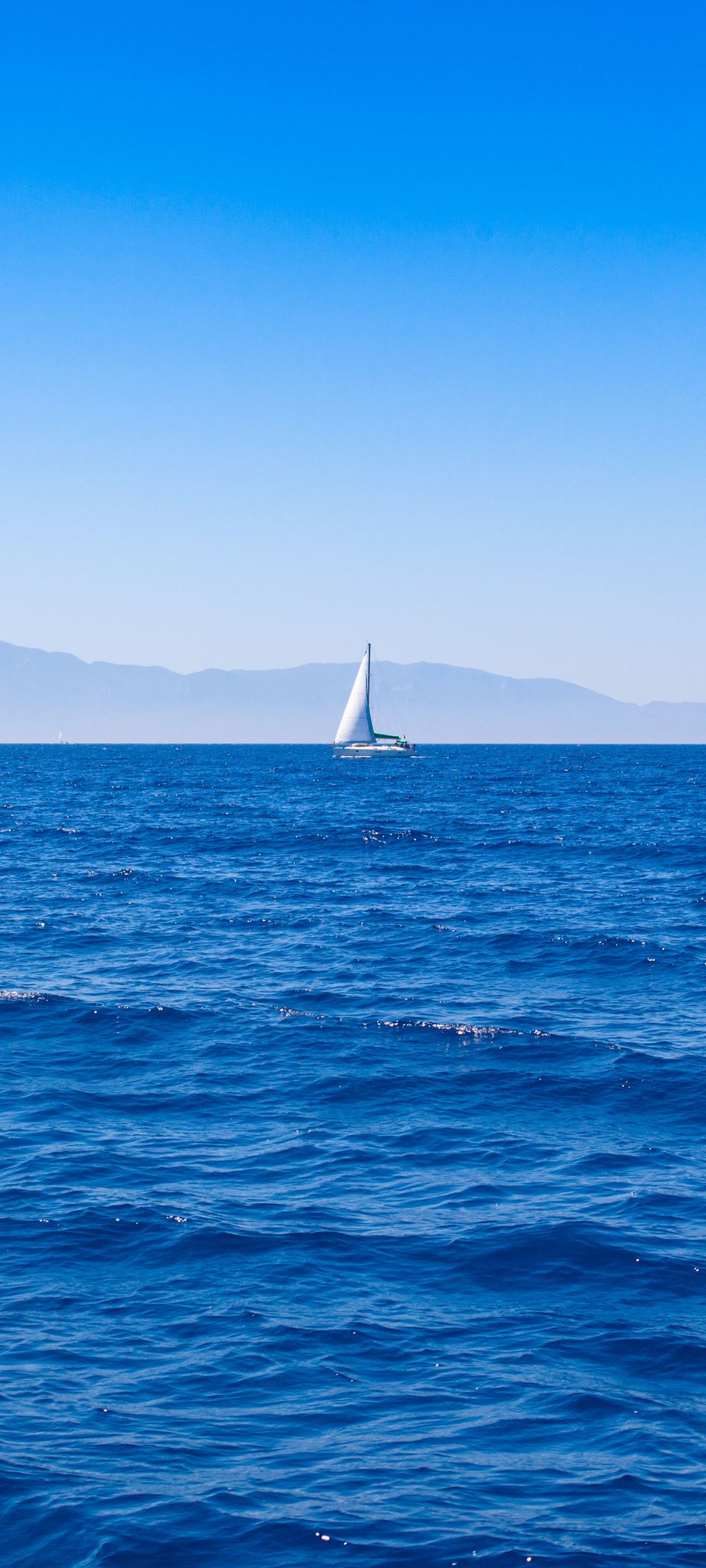 航行在蓝色大海上的白色帆船