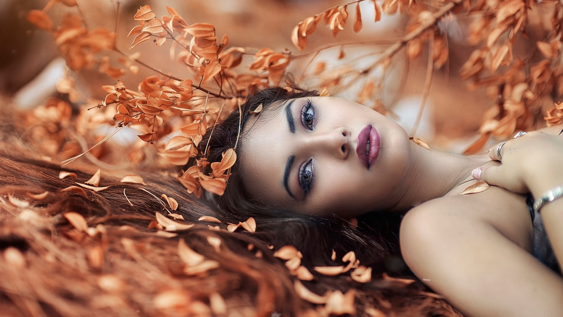 黄色秋季阳光美女躺在落叶丛