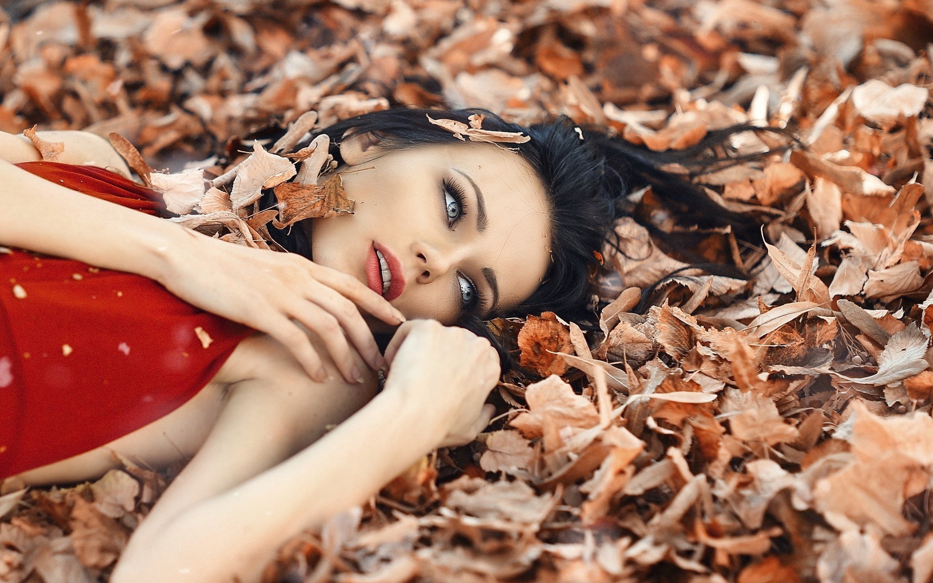 黄色秋季阳光美女躺在落叶丛